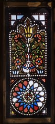 Bipartite stucco and glass window with flowers in a vase and flower and star motif