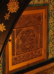 Replica of a stucco and glass window with flowers in a vase and inscription
