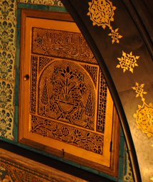 Replica of a stucco and glass window with flowers in a vase and inscription